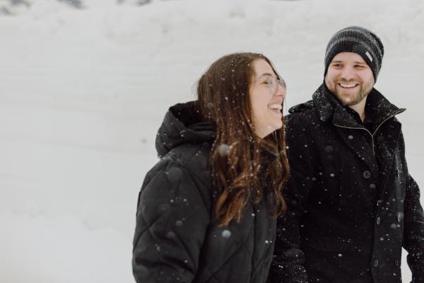couple laughing in a snowy forest