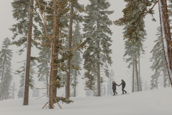 couple walking through a snowy forest